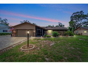 Charming single-story brick home with a well-manicured lawn and inviting curb appeal at twilight at 1515 Pecan St, Nokomis, FL 34275