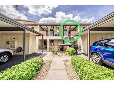 Condo with covered parking, well-maintained landscaping, and private entry stairs to the second floor at 410 Mission E Trl # B, Venice, FL 34285