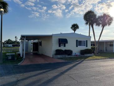 Charming mobile home with a covered carport and well-maintained landscaping at 417 Via Veneto, Venice, FL 34285