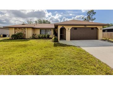 Charming single-story home with stone accents, well-manicured lawn, and a two-car garage at 4270 Ascot Dr, North Port, FL 34291