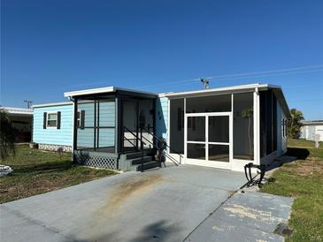 Charming blue home featuring a screened-in porch and a welcoming front entrance at 56 Lakeview Dr, North Port, FL 34287