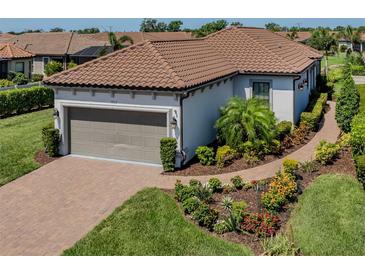 Well-maintained home with a two-car garage, beautiful landscaping, and a brick driveway at 5853 Semolino St, Nokomis, FL 34275