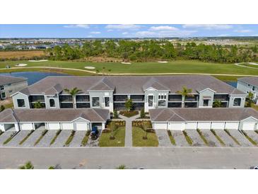 Stunning aerial view of the condo with well manicured landscaping, garages, and access to the golf course and pond at 12440 Wellen Golf St # 204, Venice, FL 34293