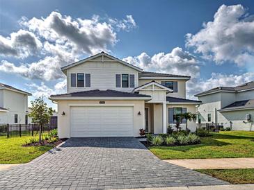 Beautiful two-story home featuring manicured lawn, brick driveway, and a two car garage at 12705 Pinnacle Ln, Venice, FL 34293