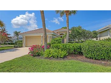 Inviting single-story home featuring a tile roof, lush landscaping, and a two-car garage at 201 Vestavia Dr, Venice, FL 34292