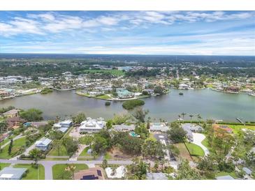 Panoramic aerial view of waterfront homes and community with lush landscaping, and a beautiful blue sky at 205 Louella Ln, Nokomis, FL 34275