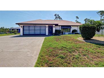Charming single-story home with a two-car garage, a well-kept lawn, and attractive landscaping at 2194 Abalom St, Punta Gorda, FL 33980