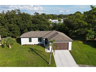 Lovely single Gathering home featuring an attached two car garage and mature landscaping in a peaceful setting at 3588 Erie Ct, North Port, FL 34287