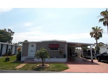 Charming single-story home with a carport, well-maintained lawn, and mature landscaping at 373 Longwood Dr, Venice, FL 34285