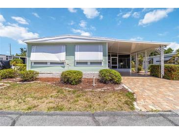 Charming single-story home with a covered carport and well-maintained landscaping and brick paved drive way at 491 Cervina Dr, Venice, FL 34285