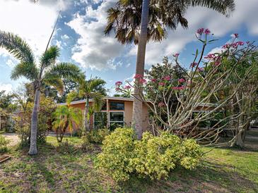 Charming single-story home featuring mature trees, native plants, and a well-manicured lawn at 602 Bonito Ave, Nokomis, FL 34275