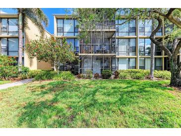 Multi-story condo building featuring lush landscaping and screened-in balconies at 618 Bird Bay S Dr # 110, Venice, FL 34285