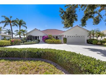 Charming single-story home boasts a well-manicured lawn and lush landscaping at 838 Carnoustie Dr, Venice, FL 34293