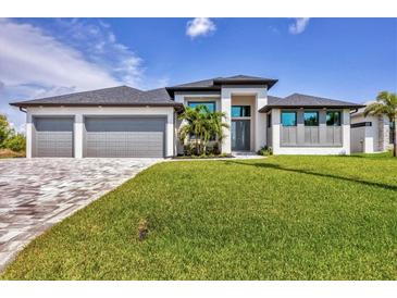 A modern two-story home with a well-manicured lawn, three-car garage, and stylish gray accents at 8634 Santa Cruz Dr, Port Charlotte, FL 33981