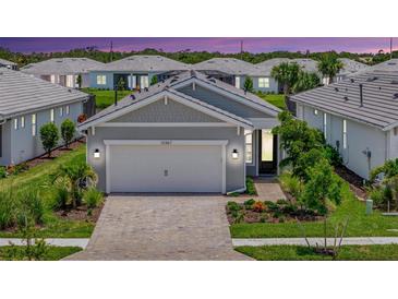 Charming single-story home with a two-car garage, paver driveway, and beautifully landscaped front yard at 10367 Abaco Falls Dr, Englewood, FL 34223