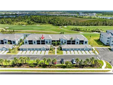 Stunning aerial view of condo with a golf course, lush landscaping and private parking at 12390 Wellen Golf St # 203, Venice, FL 34293