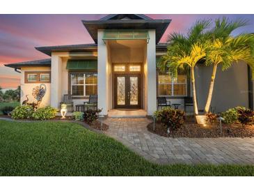 Charming home featuring a well-manicured lawn, inviting front entrance, and elegant double doors at 14398 Fort Worth Cir, Port Charlotte, FL 33981