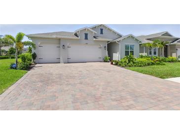 Charming single-Gathering home featuring a brick driveway, a two-car garage, and a well-manicured lawn with mature landscaping at 15963 Crofton Springs Way, Port Charlotte, FL 33953