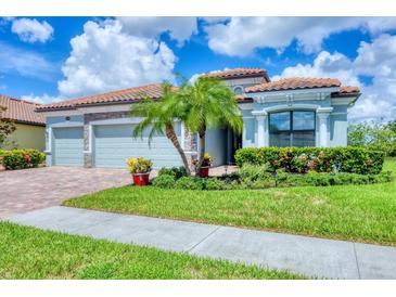 Charming single-story home featuring a three-car garage, well-manicured lawn, and lush tropical landscaping at 20235 Granlago Dr, Venice, FL 34293