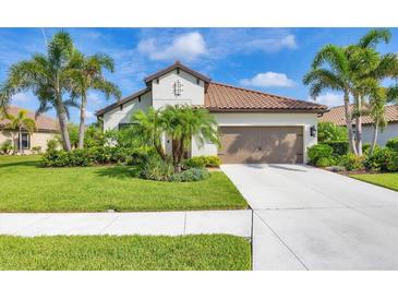Beautiful single-story home featuring a tile roof, palm trees, and a well-maintained lawn at 213 Malina Ct, Nokomis, FL 34275