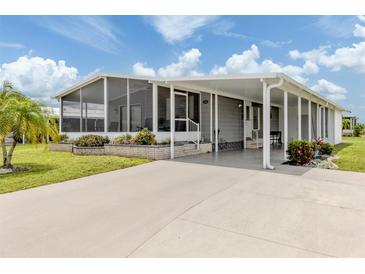 Charming single-story home featuring a covered front porch, screened-in lanai, and landscaped yard at 349 Mariner Dr, North Port, FL 34287