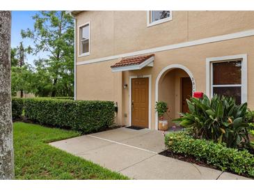Inviting townhouse exterior featuring a well-maintained front yard and charming front door at 3613 Parkridge Cir # 11-201, Sarasota, FL 34243