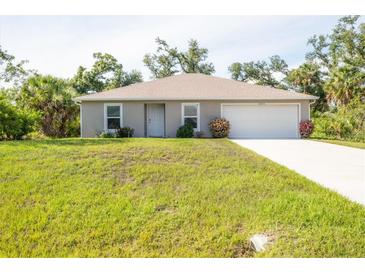 Well-maintained single-story home featuring a two-car garage, fresh landscaping, and a bright, inviting facade at 4890 Laramie Cir, North Port, FL 34286