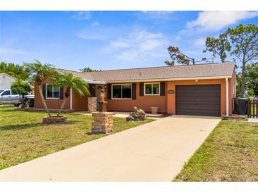 Charming single-story home featuring a well-manicured lawn and a private driveway leading to a one car garage at 7582 Lyncrest St, North Port, FL 34287