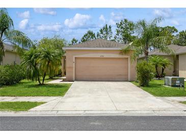 Charming single-story home with a well-manicured lawn, palm trees and a two-car garage at 11954 Tempest Harbor Loop, Venice, FL 34292