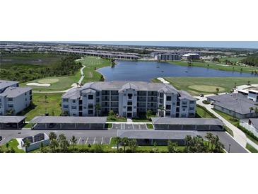 Beautiful aerial view of the condo community with a pond, golf course, and covered parking at 12140 Wellen Golf St # 202, Venice, FL 34293