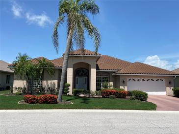 Charming single-story home featuring a tile roof, well-manicured lawn, and lush landscaping at 1345 Reserve Dr, Venice, FL 34285