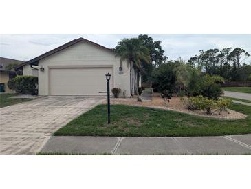 Charming single-story home with a well-manicured lawn and attached two-car garage at 14261 Palm Ter, Port Charlotte, FL 33953