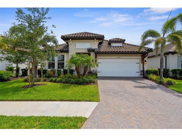 Charming single-story home with lush landscaping and a brick-paved driveway at 19927 Bridgetown Loop, Venice, FL 34293