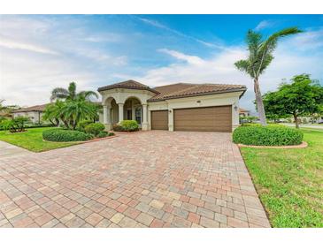Stunning home with a tile roof, arched entryway and brick paver driveway at 20169 Cristoforo Pl, Venice, FL 34293