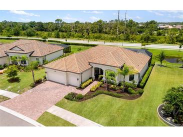 Stunning home with a tile roof, well-manicured lawn, and a three car garage at 20443 Cristoforo Pl, Venice, FL 34293