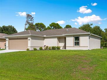 Charming single-story home with a well-manicured lawn and attached two-car garage on a sunny day at 2355 Allsup Ter, North Port, FL 34286