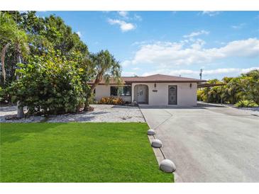Charming single-story home with a well-manicured lawn and inviting curb appeal, complemented by lush tropical landscaping at 2555 Yucca Rd, Venice, FL 34293