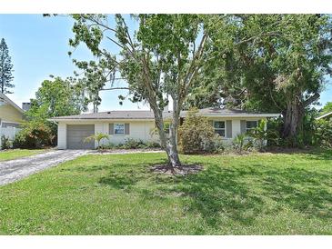 Inviting single-story home with a well-manicured lawn and mature trees creating a serene and picturesque setting at 3340 Webber St, Sarasota, FL 34239