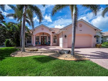 Inviting home featuring lush landscaping, mature palms, and a charming front patio at 4308 Via Del Santi, Venice, FL 34293