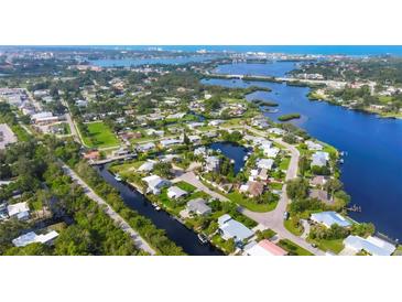 Stunning aerial view of waterfront homes and canals in a lush, tropical community with beautiful blue waterways at 458 Ceil Ct, Nokomis, FL 34275