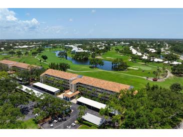 Beautiful aerial view of a condo complex with a golf course and pond in the background at 849 Wexford Blvd # 849, Venice, FL 34293