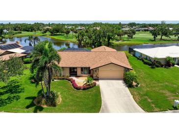 Charming single-story home with well-manicured lawn, landscaping, and water views at 925 S Doral Ln, Venice, FL 34293