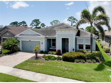 Charming single-story home with beautiful landscaping and a welcoming front porch swing at 11560 Tapestry Ln, Venice, FL 34293