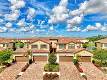 Beautiful, sunny aerial view of townhomes with brick driveways and manicured landscaping at 12590 Ghiberti Cir # 201, Venice, FL 34293