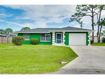 Charming green single-story home with manicured lawn and white trimmed windows and a white garage door at 1536 Porpoise Rd, Venice, FL 34293