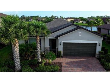 Charming single-story home with lush tropical landscaping and a brick driveway at 2487 Marton Oak Blvd, North Port, FL 34289