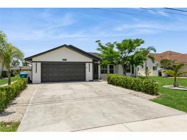 Charming single-story home featuring a well-maintained lawn, a two-car garage, and neatly trimmed landscaping at 26115 Rampart Blvd, Punta Gorda, FL 33983