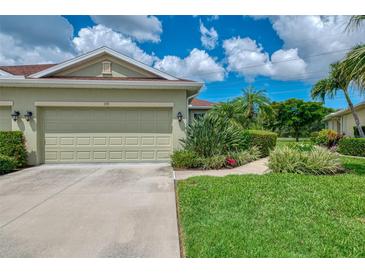Charming home featuring an attached garage and lush tropical landscaping at 371 Capulet Dr, Venice, FL 34292