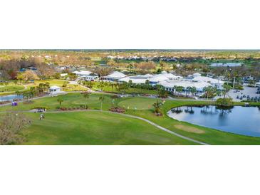 An aerial view of the golf course and clubhouse featuring manicured lawns and lush landscaping at 408 Cerromar S Cir # 331, Venice, FL 34293