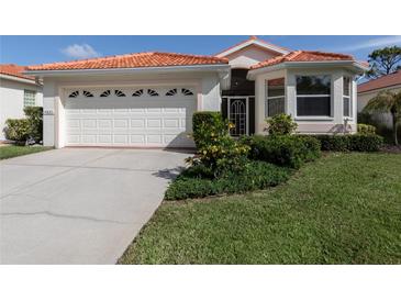 Charming single-story home featuring a red tile roof, well-manicured lawn, and an attached two-car garage at 4831 Summertree Rd, Venice, FL 34293